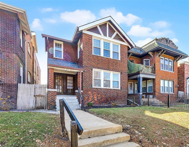 view of front of house with a front yard, fence, and brick siding