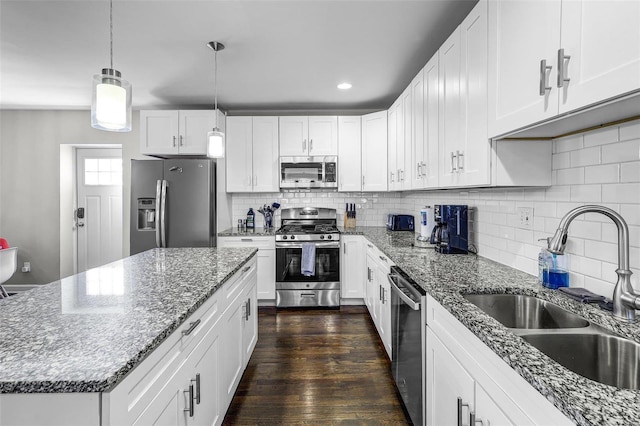 kitchen featuring a sink, a kitchen island, appliances with stainless steel finishes, white cabinets, and dark wood-style flooring