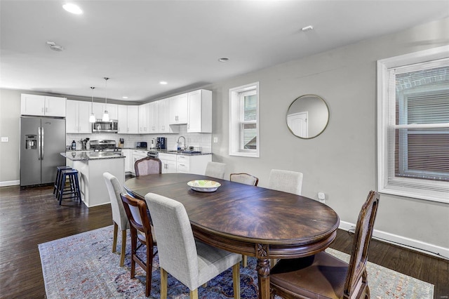 dining room with dark wood finished floors, recessed lighting, and baseboards