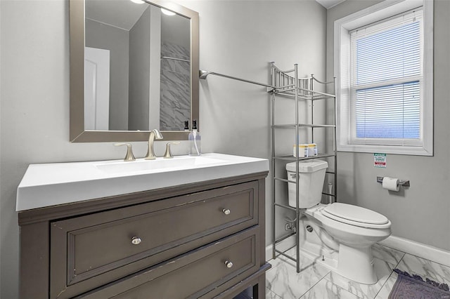 bathroom with vanity, toilet, baseboards, and marble finish floor