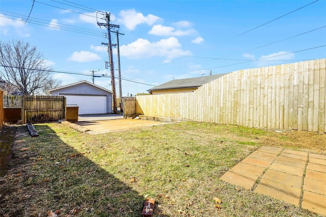 view of yard featuring an outdoor structure, a fenced backyard, a detached garage, and a patio