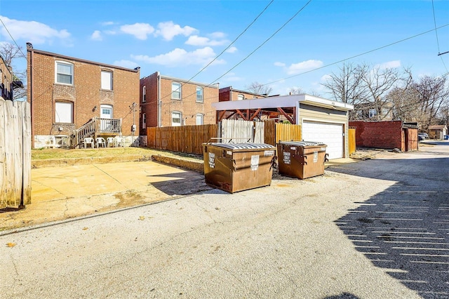 exterior space with a detached garage, an outdoor structure, and fence