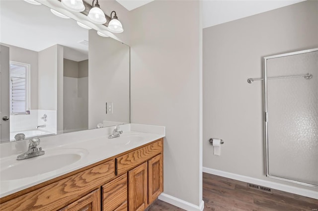 bathroom with an inviting chandelier, a shower, baseboards, and a sink