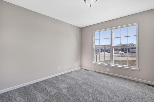 carpeted empty room with visible vents and baseboards