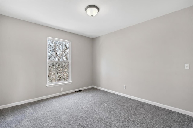 empty room with baseboards, carpet floors, and visible vents