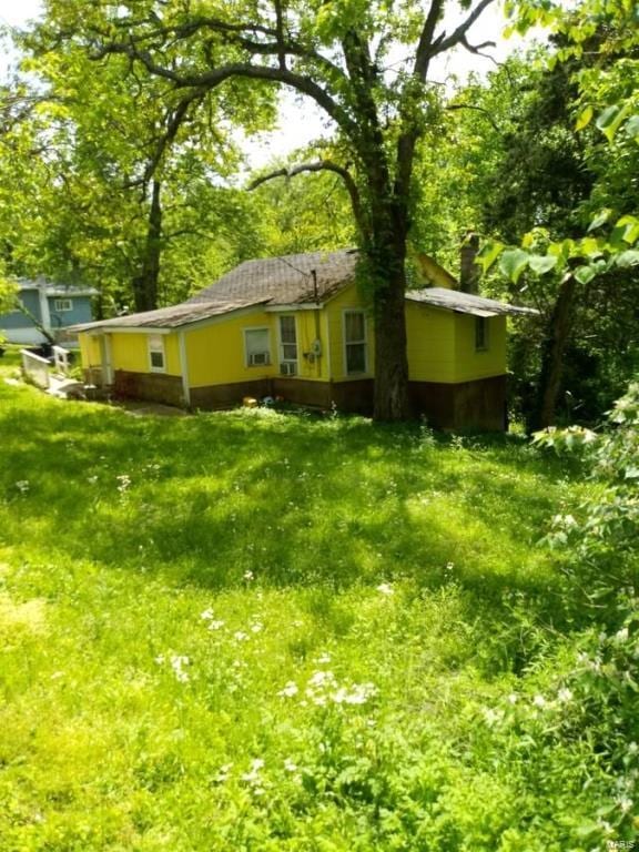 rear view of property with a lawn