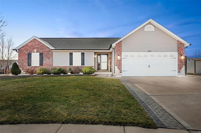 ranch-style home with a front yard, roof with shingles, concrete driveway, a garage, and brick siding