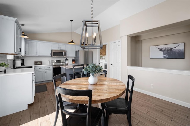 dining space with baseboards, dark wood-type flooring, separate washer and dryer, and vaulted ceiling