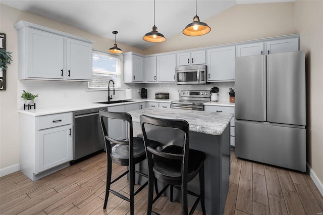 kitchen with tasteful backsplash, a breakfast bar area, light wood-style flooring, stainless steel appliances, and a sink