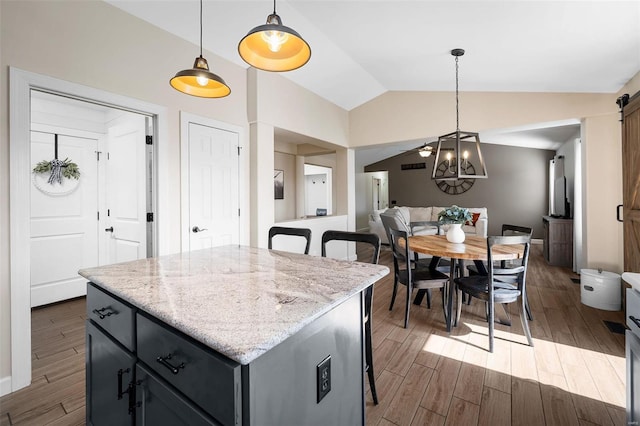 kitchen featuring dark wood-style floors, a kitchen island, lofted ceiling, and a breakfast bar