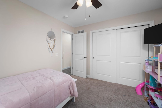 bedroom with a closet, carpet flooring, a ceiling fan, and visible vents