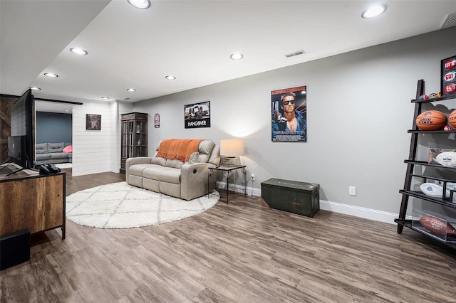 living room featuring recessed lighting, visible vents, baseboards, and wood finished floors