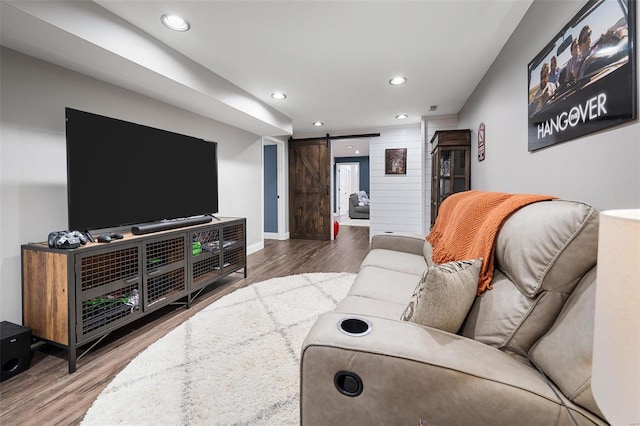 living area featuring recessed lighting, baseboards, a barn door, and wood finished floors