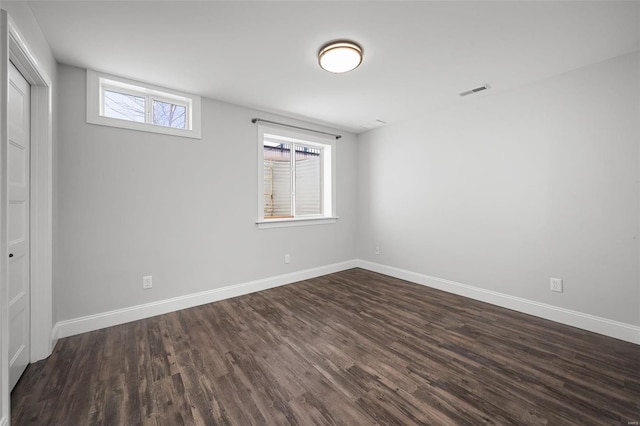 interior space with dark wood finished floors, visible vents, and baseboards