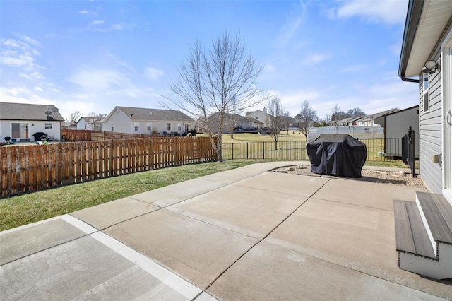 view of patio with grilling area, a residential view, and a fenced front yard