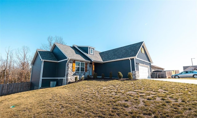 view of front of home featuring fence, a front yard, a garage, stone siding, and driveway