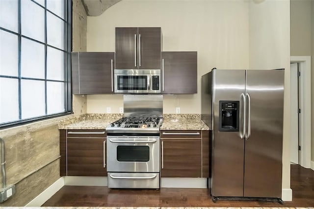 kitchen with dark brown cabinetry, stainless steel appliances, and modern cabinets