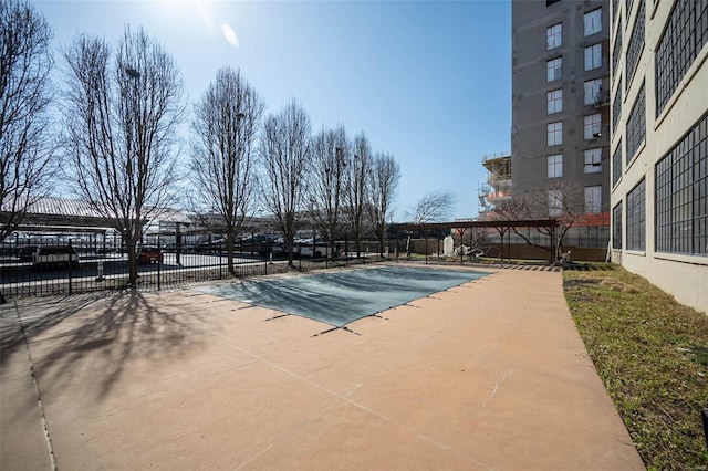 pool with a patio area and fence