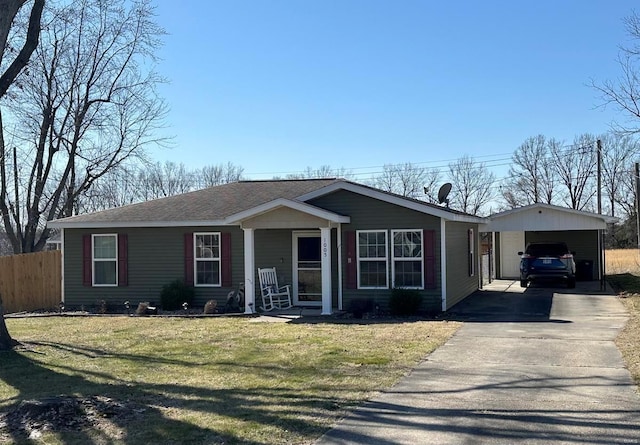 view of front of home featuring driveway, roof with shingles, a front yard, and fence