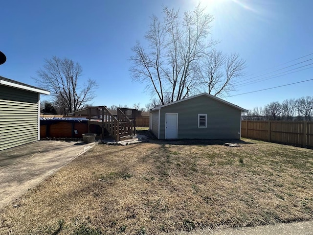 view of yard featuring a deck, an outdoor structure, and fence