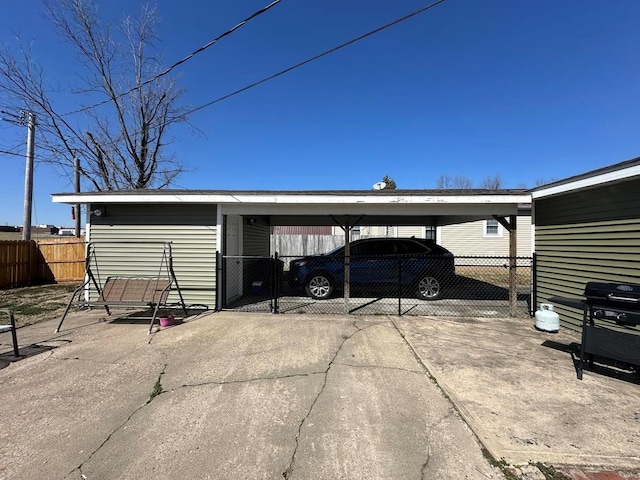 view of vehicle parking featuring a carport, concrete driveway, and fence