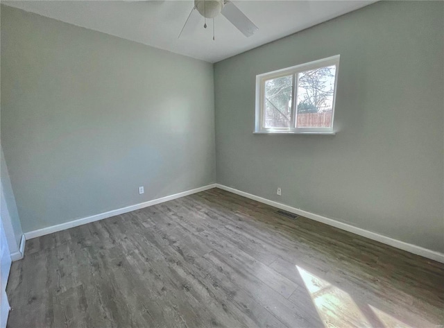 unfurnished room featuring ceiling fan, visible vents, baseboards, and wood finished floors