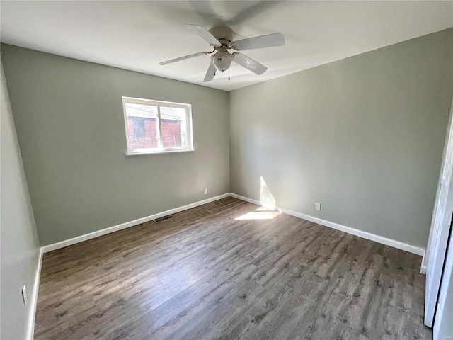 empty room featuring visible vents, baseboards, wood finished floors, and a ceiling fan