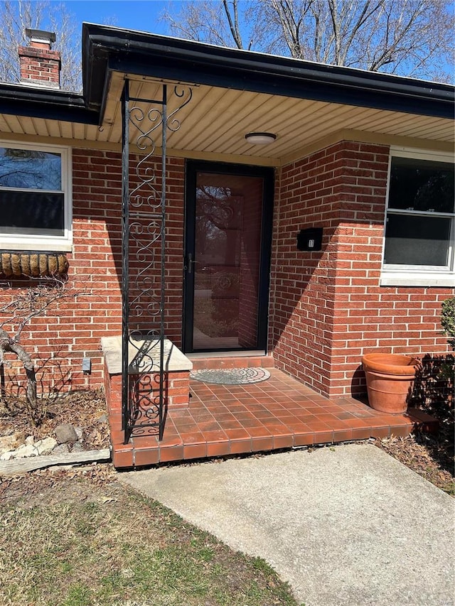 doorway to property with brick siding