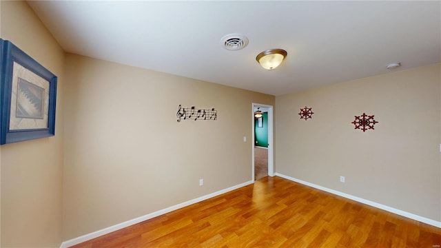 spare room featuring visible vents, baseboards, and light wood-style flooring