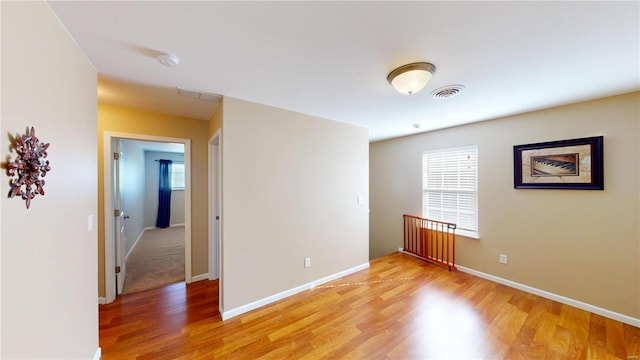 empty room featuring visible vents, baseboards, and light wood-style floors