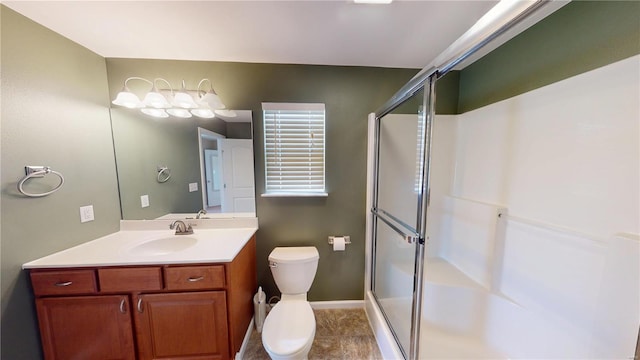 bathroom featuring a shower stall, toilet, vanity, and baseboards