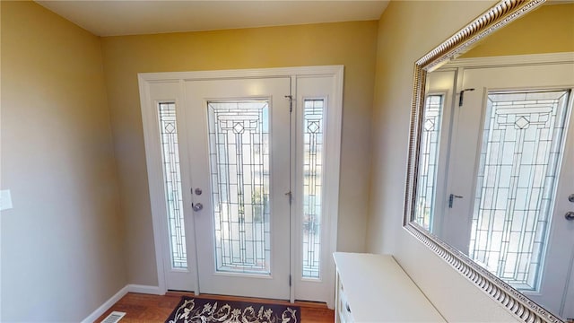 foyer entrance featuring plenty of natural light, baseboards, and wood finished floors