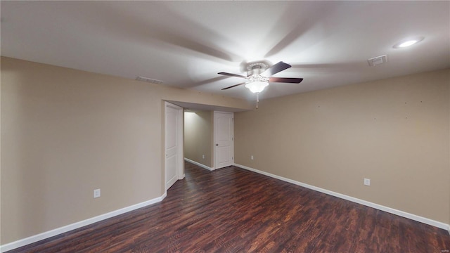 unfurnished room featuring dark wood finished floors, visible vents, baseboards, and a ceiling fan