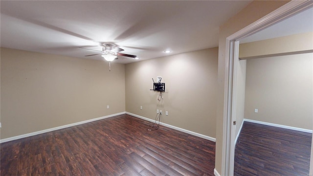 empty room with wood finished floors, a ceiling fan, and baseboards