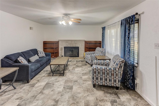 living room with visible vents, ceiling fan, and a glass covered fireplace