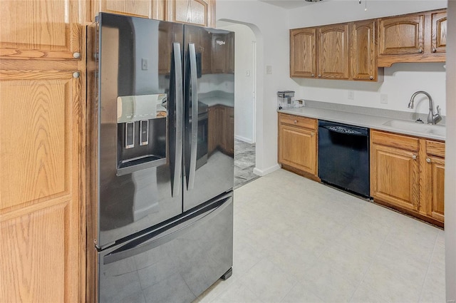 kitchen featuring dishwasher, light countertops, fridge with ice dispenser, arched walkways, and a sink