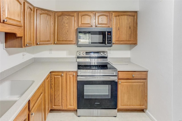 kitchen featuring a sink, stainless steel appliances, and light countertops