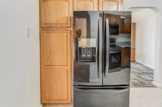 kitchen with tile patterned floors, stainless steel fridge with ice dispenser, arched walkways, and baseboards