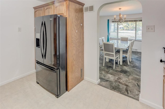 kitchen featuring visible vents, an inviting chandelier, arched walkways, light brown cabinetry, and black fridge with ice dispenser