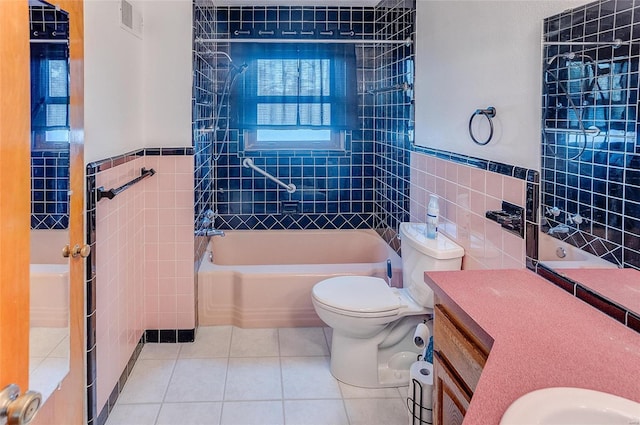 bathroom featuring tile patterned flooring, tile walls, toilet, and bathing tub / shower combination