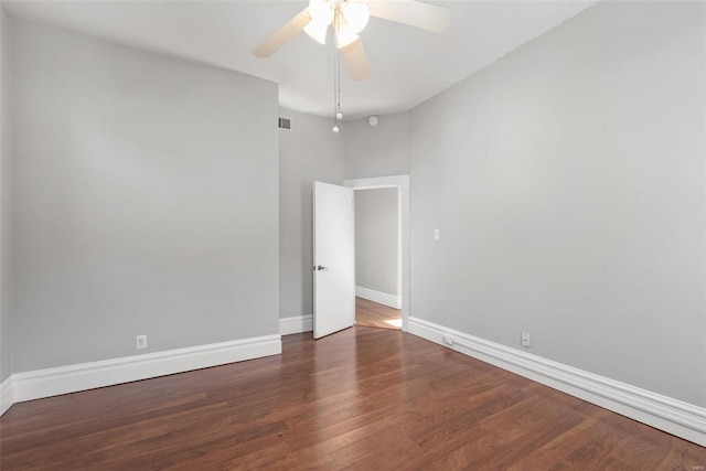 empty room with visible vents, a ceiling fan, baseboards, and wood finished floors