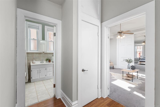 hallway featuring wood finished floors and baseboards