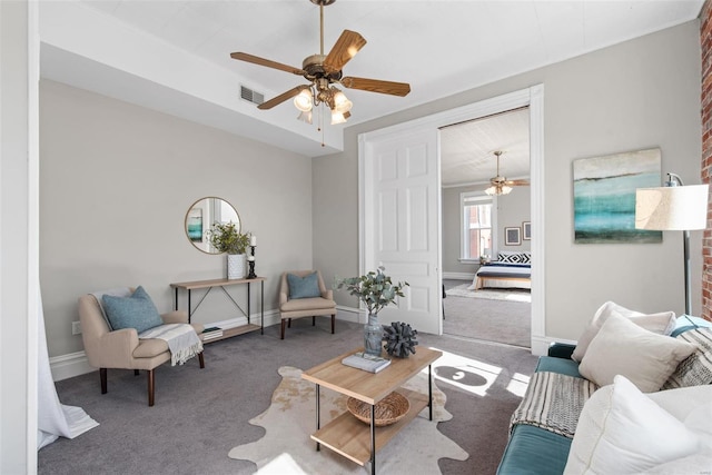 carpeted living area with visible vents, baseboards, and a ceiling fan