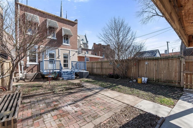 exterior space with cooling unit and a fenced backyard