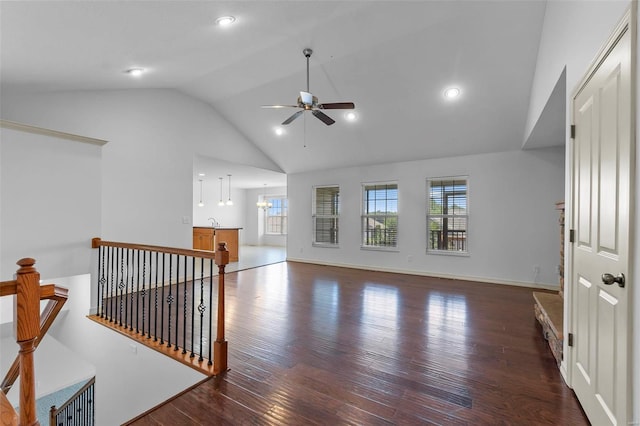 living area with high vaulted ceiling, ceiling fan with notable chandelier, wood finished floors, recessed lighting, and baseboards