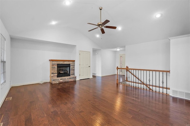 unfurnished living room with visible vents, a stone fireplace, wood finished floors, and a ceiling fan