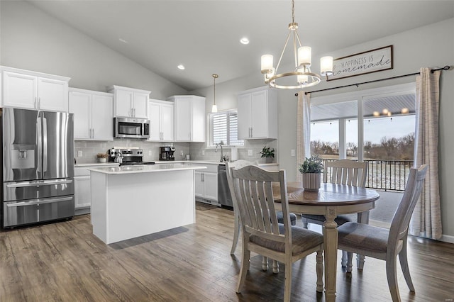 kitchen with a kitchen island, appliances with stainless steel finishes, white cabinets, and light countertops