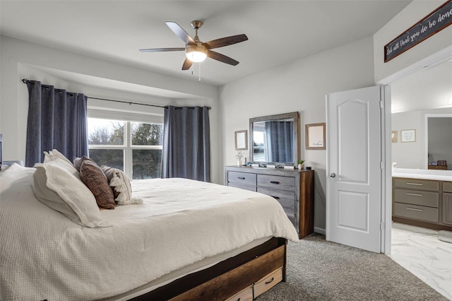 bedroom featuring marble finish floor, ensuite bath, and a ceiling fan