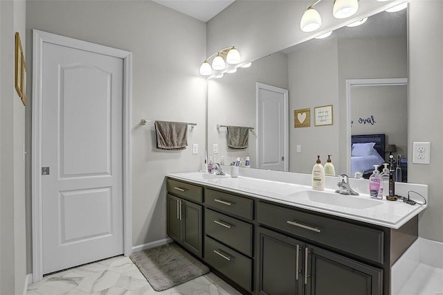 full bath with double vanity, marble finish floor, ensuite bathroom, and a sink