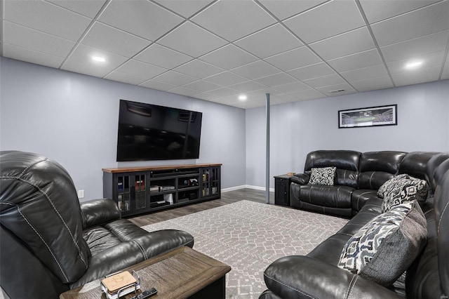 living area featuring wood finished floors, baseboards, and a paneled ceiling